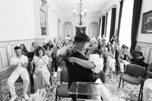 Jeunes mariés s’embrassant joyeusement dans la mairie d’Uzès après avoir échangé leurs vœux de mariage organisé par Version Luxe Evénements leur wedding planner
