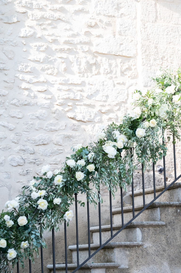 Rambarde escalier decoré par une une guirande de fleurs composée de verdure et de pivoines blanches